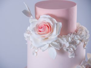 Beautiful elegant four tiered pink wedding cake decorated with roses flowers. The concept patisserie floral from sugar mastic